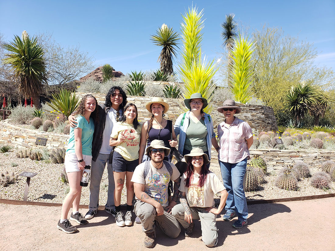 Students posing in front of desert