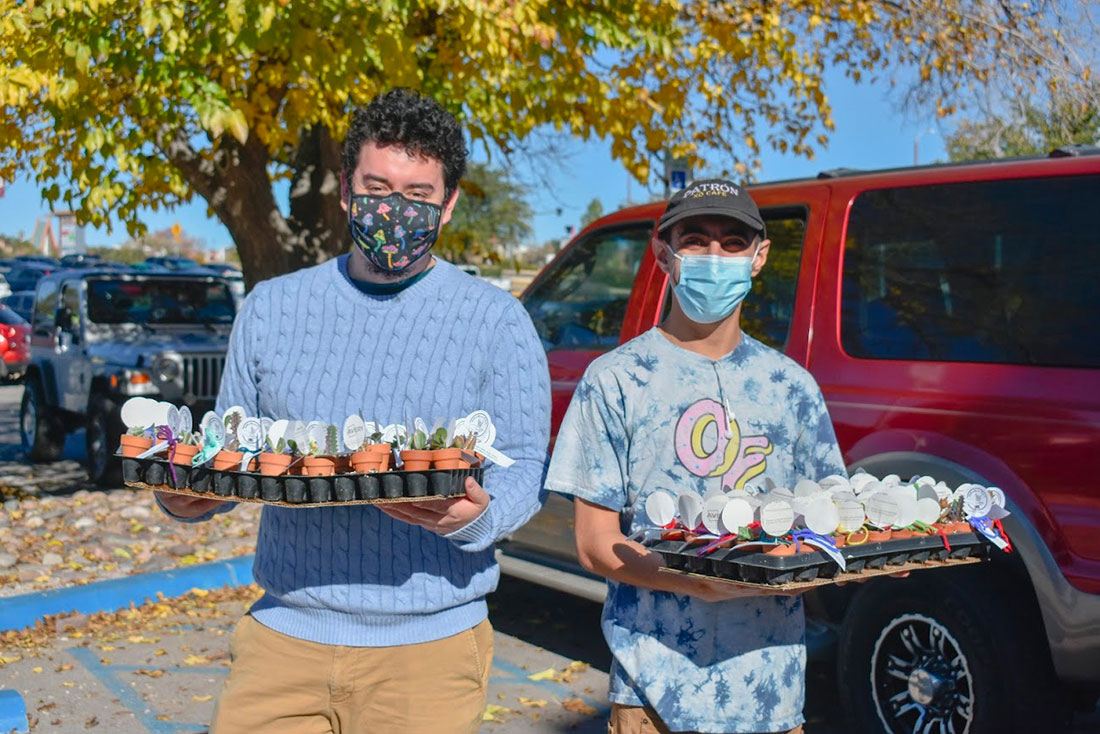 Two students holding plant seedlings